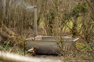 Somerset Shepherds Huts في Winsham: وجود حوض استحمام في وسط الغابة