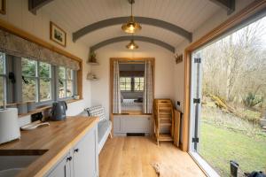 a kitchen with a large window in a tiny house at Somerset Shepherds Huts in Winsham