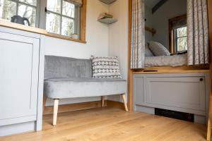 a living room with a bench and a mirror at Somerset Shepherds Huts in Winsham