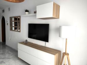 sala de estar con TV en una pared blanca en Dream Sea Golf & Beach, en Benalmádena