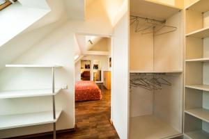 een inloopkast met witte kasten en een slaapkamer bij Schlossquadrat Apartment 16 in Wenen