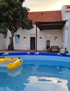 a swimming pool with a yellow raft in the water at Casa Magana em Grândola in Grândola