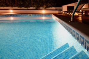 uma grande piscina com azulejos azuis em Villa ELTAEL - Casa Daniel - Piscina Aquecida e Partilhada em Manta Rota