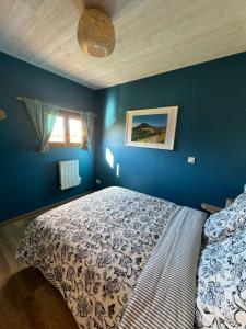 - une chambre dotée d'un lit avec un mur bleu dans l'établissement Chalets "Ô Cœur des Puys", à Ceyssat