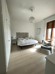 1 dormitorio con 1 cama y 1 silla en La Signora Dei Fiori, en Gubbio