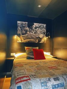 a bedroom with a large bed with a painting on the wall at La Villa del Karting in El Teso