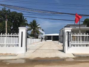 a white fence with a red flag on top of it at Thanh Tuan Motel in Vinh Hoa