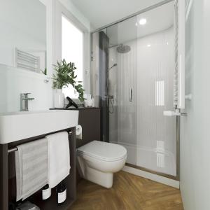 een witte badkamer met een toilet en een douche bij MORENIA Park Villas in Podaca
