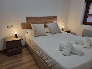 ein Schlafzimmer mit einem großen weißen Bett mit zwei Kerzen darauf in der Unterkunft 119D2 Apartamento con encanto en pleno centro in Gijón