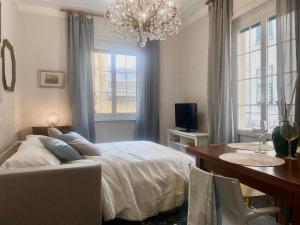 una camera con letto, tavolo e lampadario a braccio di CasaViva- Ampio appartamento nei vicoli di Genova a Genova