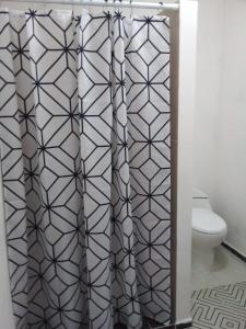 a bathroom with a shower curtain and a toilet at HospedArte Loreto in Loreto