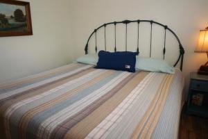 a bed with a blue pillow on top of it at Bandit's Hideaway-The Loft in Wimberley