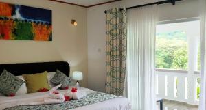 a bedroom with a bed with stuffed animals on it at Mountain View Hotel in La Digue