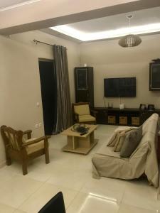 a living room with a couch and a tv at Sabbia Beach House in Alykes