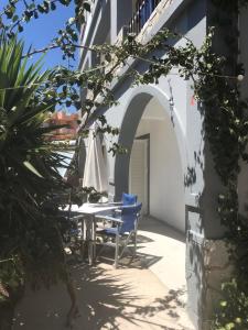 a patio with a table and chairs and an umbrella at Sabbia Beach House in Alykes +11 photos