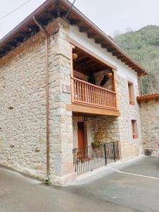 - un bâtiment en pierre avec un balcon sur le côté dans l'établissement La Texuca, à Carreña de Cabrales
