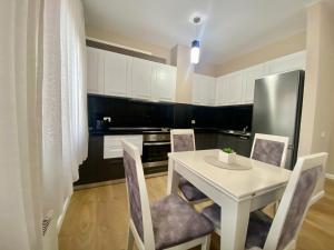 a kitchen with a white table and chairs and a refrigerator at Tirana New Bazaar- Apartment no-1 in Tirana