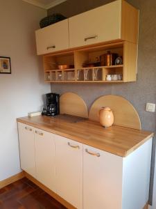 una cucina con armadi bianchi e ripiano in legno di Chalet Malmedy a Malmedy