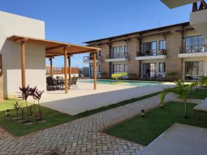 Praia Da CaueiraにあるFlat Praia da Caueira - Flat com piscina a 100m da praiaのスイミングプール付きの建物の中庭