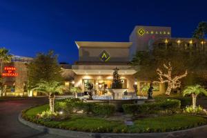 a hotel with a fountain in front of a building at Hotel Araiza Mexicali in Mexicali