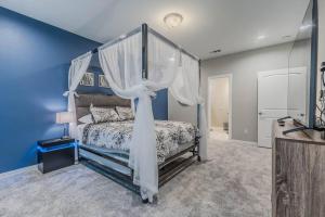 a bedroom with a canopy bed and blue walls at Modern 4 BR Near Downtown, Zoo in Dallas