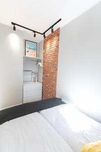 1 dormitorio con pared de ladrillo junto a la cama en Apartament Gdańsk Centrum, en Gdansk