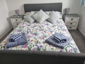 a bed with two pillows on it in a bedroom at Anniversary Cottage- Country feel, close to Cromer in Northrepps