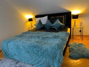 1 dormitorio con 1 cama grande con manta azul en Comfort Zone Ostróda Villa Apartment C en Ostróda