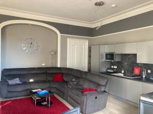 a living room with a couch and a kitchen at Luxury Apartment at Barron House in Nairn