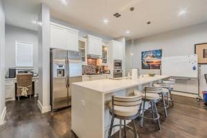 a kitchen with a large island with bar stools at Stunning Townhome Near Uptown in Dallas