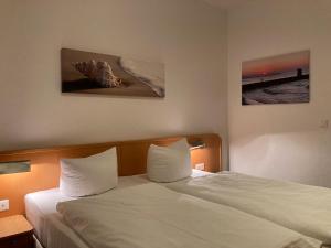 ツェンピンにあるApartment Arianeのベッドルーム1室(ベッド2台付)が備わります。壁には絵画が2点飾られています。
