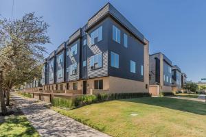 a large black building with a grass yard in front of it at Stunning Townhome Near Uptown in Dallas
