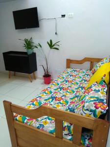 uma cama com um edredão colorido num quarto em Loft Aconchegante no Centro de Niterói! em Niterói