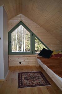 Habitación con cama y ventana grande. en Ogród Shinrin Yoku (Haru) Odpoczynek w Lesie en Srokowo