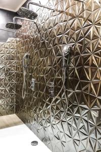 a shower in a bathroom with a tiled wall at Velezia LOVE in Roujan