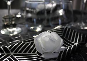 a white flower on a black and white table cloth at Velezia LOVE in Roujan