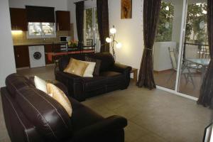 een woonkamer met 2 banken en een keuken bij The well-equipped luxury apartment Paphos Riviera in Paphos City