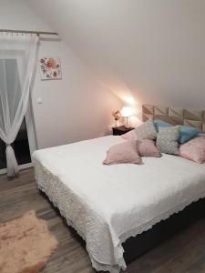 a bedroom with a bed with pink and blue pillows at Domki Prowansalskie in Mysłakowice