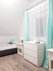 a bedroom with a bed and a sink and a mirror at Domki Prowansalskie in Mysłakowice