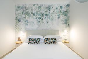 a white bedroom with a white bed with pillows at Chez Rosa - Cozy sea view openspace - 10mins from Belmond Caruso Ravello in Ravello