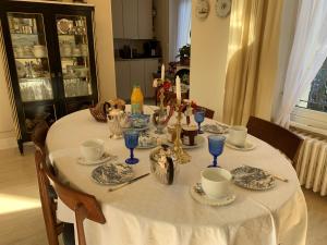サン・マロにあるVilla Hébertのダイニングルームテーブル(白いテーブルクロス、青いグラス付)