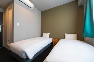 two beds in a small room with white sheets at IMANO OSAKA SHINSAIBASHI HOSTEL - Vacation STAY 27589v in Osaka