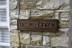una señal en el costado de una pared de piedra en The Hideaway, en Alston