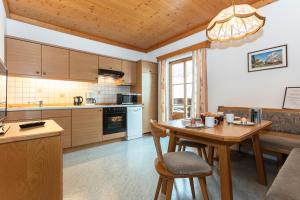 a kitchen with a wooden table and a dining room at Biobauernhof Stegerbauer in Maria Alm am Steinernen Meer