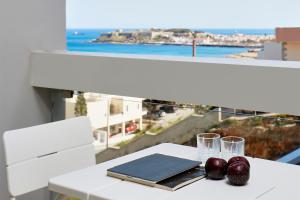 a white table with two glasses and a plate of fruit at VIVIAN Art Apartments in Rethymno Town