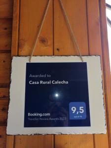 a sign is hanging on a wooden wall at Casa Rural Calecha in Caboalles de Abajo