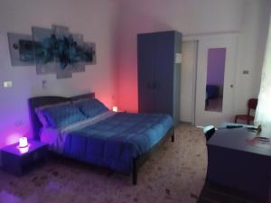 Un dormitorio con una cama azul y una mesa en All inBasilicata Bed & Breakfast, en Baragiano