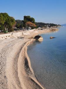 una playa rocosa con un puente en el agua en Anita en Zaostrog