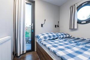 niewielka sypialnia z łóżkiem i oknem w obiekcie Domek na wodzie Topiko Czarter - jezioro Mamry w Węgorzewie