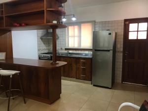una cocina con nevera de acero inoxidable y armarios de madera en Duplex Salvat en Puerto Iguazú